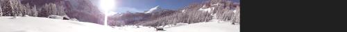 two photographs of people skiing down a snow covered slope at Hotel Albe in Rocca Pietore