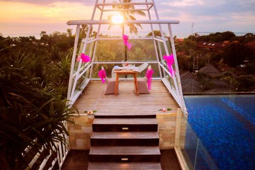 a wooden bridge over a pool with a table on it at FOX Hotel Jimbaran Beach Bali in Jimbaran