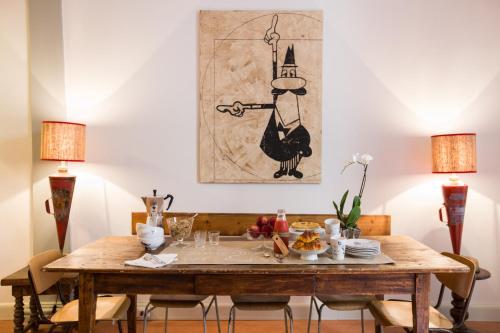 a dining room with a wooden table with two lamps at Soprarno Suites in Florence