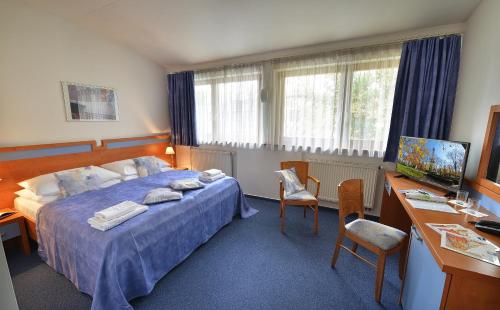 a hotel room with a bed and a desk with a computer at EA Hotel Populus in Prague