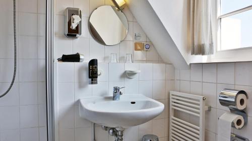 a bathroom with a sink and a mirror at Hotel Am Schloss in Alzey