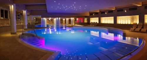 a pool in a hotel with blue and pink lighting at Hotel Slovenija - Terme & Wellness LifeClass in Portorož