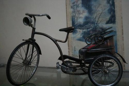 a black bike parked next to a wall at Kembar Guesthouse in Yogyakarta