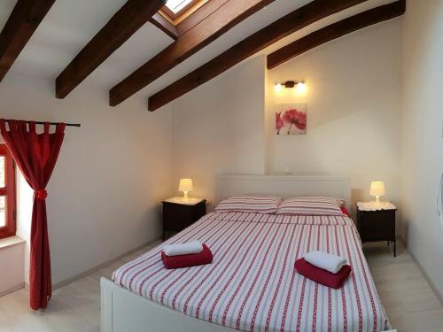a bedroom with a bed with two red pillows on it at Mon Perin Castrum - Casa Felice in Bale