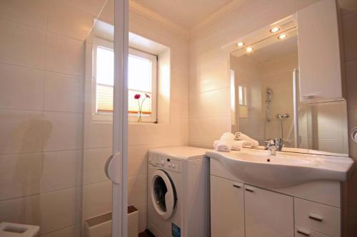 a bathroom with a washing machine and a sink at Almliesl ZELL-448 in Zell am See