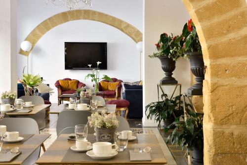 a dining room with tables and chairs and a tv at Viacolvento in Marsala