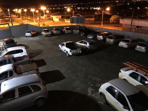 a bunch of cars parked in a parking lot at night at Lider Hotel in Jataí