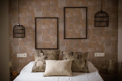 a bedroom with a bed with two pictures on the wall at Luces de Catedral in Alicante