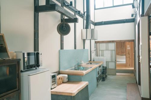 a large kitchen with a sink and a tv at Casa OGUMO in Kyoto