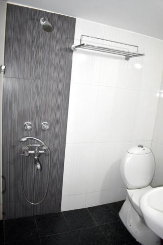 a bathroom with a shower with a toilet and a sink at Tranquil Hospitality with Breakfast in Bhubaneshwar