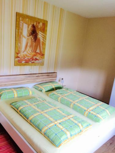 two beds in a room with a painting on the wall at Urlaub auf dem Bauernhof Marx in Kelberg
