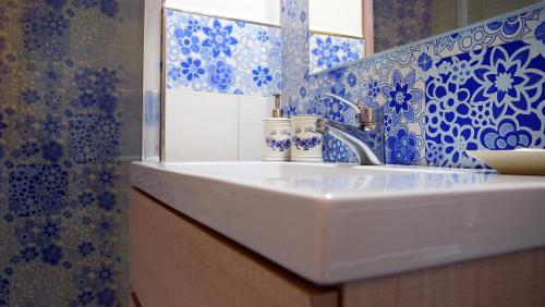 bagno con lavandino e piastrelle bianche e blu di Arte & Mare a Patti