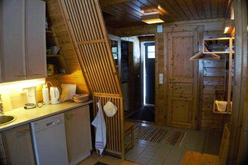 a kitchen with a staircase in a tiny house at Ylläs Suistotie Cottage in Äkäslompolo