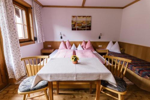 a dining room with a table and two beds at Gaestehaus Berger in Sankt Jakob in Defereggen