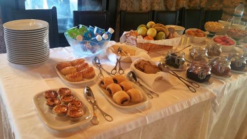 アギアル・ダ・ベイラにあるQuinta de Santo Estêvão Hotel Ruralのペストリーを数皿かけたテーブル