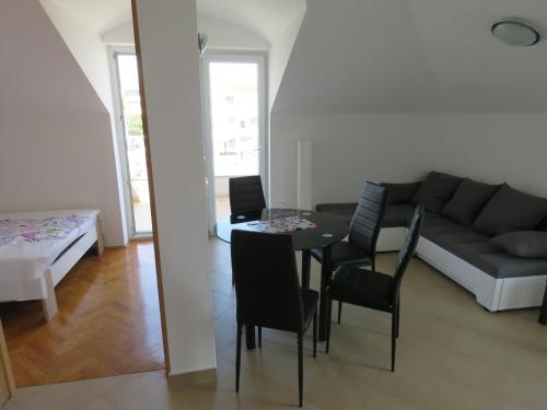 ein Wohnzimmer mit einem Sofa, einem Tisch und Stühlen in der Unterkunft Apartment STAR in Novalja