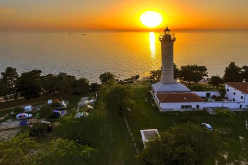 an aerial view of a lighthouse with the sunset in the background at Villas Faro in Bašanija