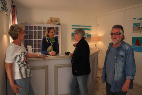 a group of people standing around a counter at Résidence l'Oustal des Mers in Gruissan
