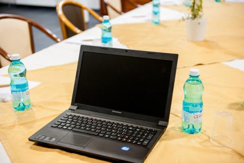 a laptop computer sitting on a table with two bottles of water at Hotel Florence in Lourdes