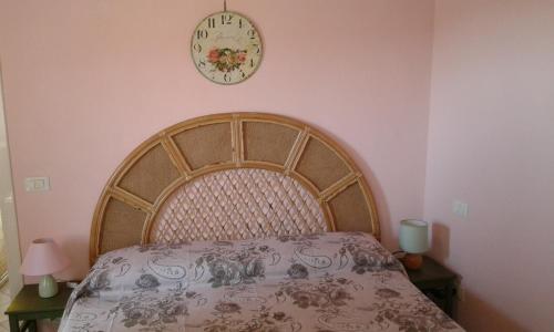 a bedroom with a bed and a clock on the wall at La Maison Galu' in Itri