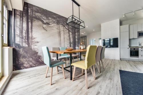 a dining room with a wooden table and chairs at Apartamenty Sun & Snow Przy Monte Cassino in Sopot
