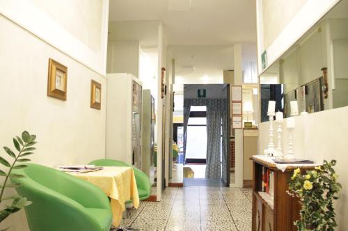 Cette chambre comprend une table et des chaises vertes. dans l'établissement Hotel Del Sud, à Milan