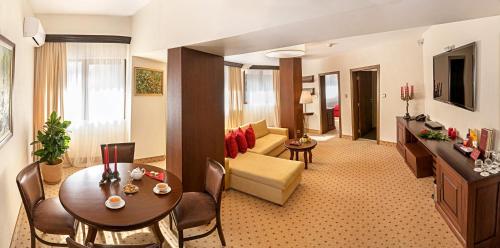 a living room with a couch and a table at Hotel Yastrebets Wellness & Spa in Borovets