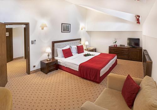 a hotel room with a bed and a couch at Hotel Yastrebets Wellness & Spa in Borovets