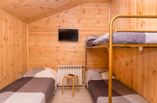 ヴィボルグにあるTurbaza Scandi Land Apartments с зоной барбекю Выборгの木造キャビン内の二段ベッド2台が備わる客室です。