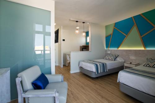 a bedroom with a bed and a couch and a chair at ApartHotel Idafe in Las Palmas de Gran Canaria