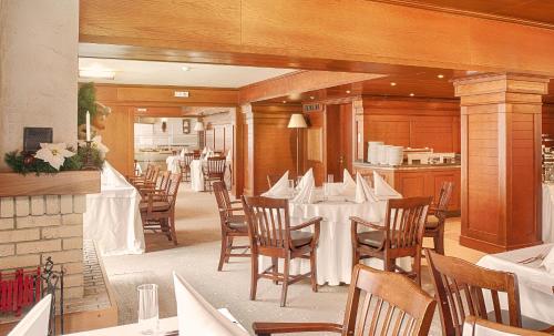 a dining room with tables and chairs in a restaurant at Hotel Yastrebets Wellness & Spa in Borovets