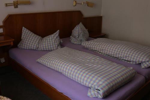 Hotel Ristorante Ätna في Ulrichstein: سريرين عليهما وسائد في غرفة النوم