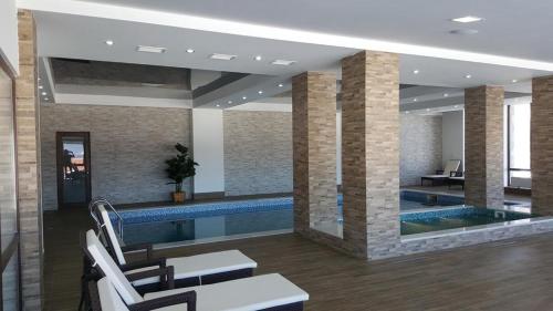 - une piscine dans un bâtiment avec des chaises et une table dans l'établissement Villa (second floor) in CRYSTAL, à Bakuriani