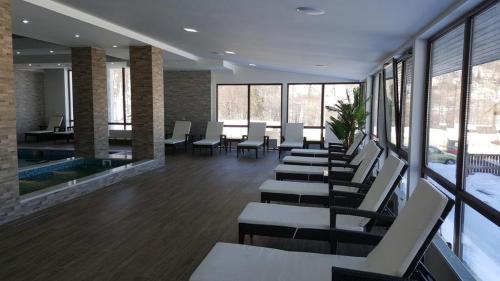 a waiting room with chairs and tables and windows at Villa (second floor) in CRYSTAL in Bakuriani