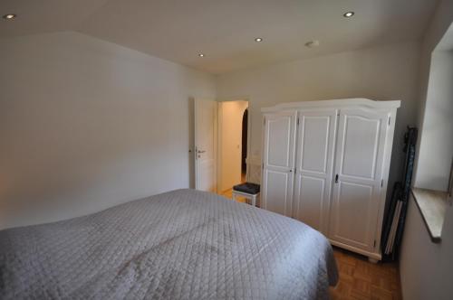 ein Schlafzimmer mit einem weißen Bett und einem Schrank in der Unterkunft Apartment am Mohrenplatz in Garmisch-Partenkirchen