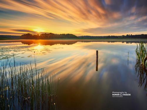 a reflection of the sunset on a lake at Holiday Home in Skrzynia near Lake & Forest in Osiek