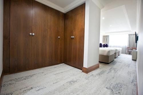 a bedroom with wooden cabinets and a bed in a room at Sanctum Maida Vale in London
