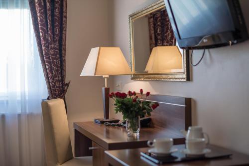 
a table with a lamp and a vase on it at Jasek Premium Hotel Wrocław in Wrocław
