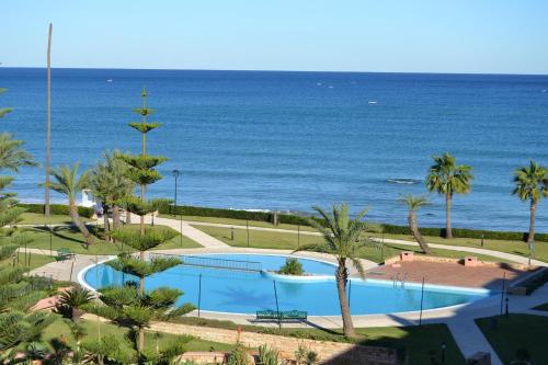 a swimming pool with the ocean in the background at Marina Beach Appartements in Restinga Smir