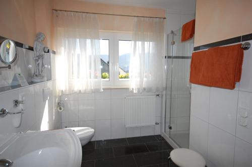 a bathroom with a sink and a toilet and a window at Ferienweingut Port in Bernkastel-Kues