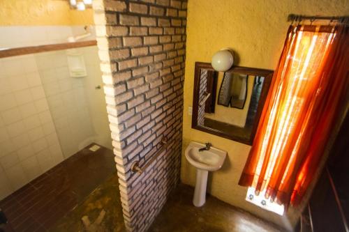 Pousada Cabanas de Búzios في نيسيا فلوريستا: حمام مع حوض ومرآة