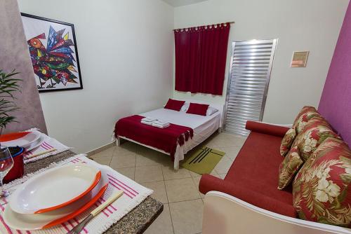 a small room with a bed and a couch at Residencial Elenita in Boicucanga