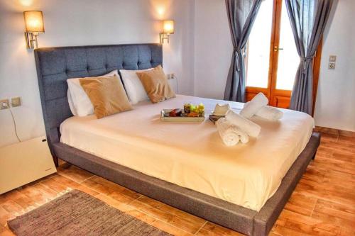 a large bed with a tray of fruit on it at Araucaria House in Skiathos
