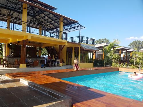 a pool at a resort with people in it at Slow Life Sabaidee Pai in Pai