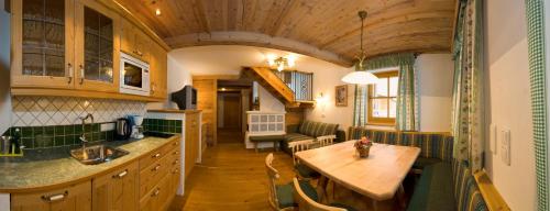 een keuken met een houten tafel in een kamer bij Appartmenthof Aigengut Ferienwohnung Großarl in Grossarl