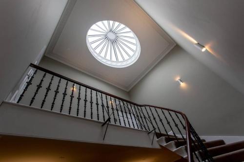 a spiral staircase with a round window on the ceiling at ALTIDO Spacious 2BR Apt, moments from West End in Edinburgh