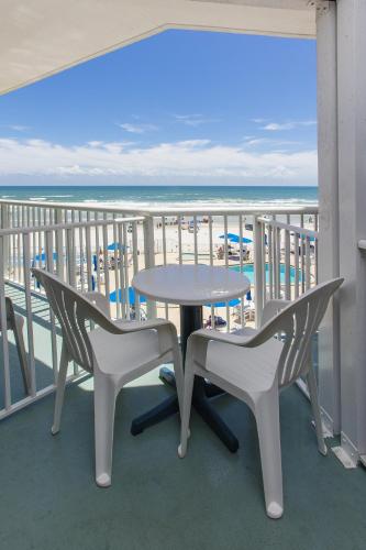 a table and chairs on a balcony with the beach at Sea Club IV Resort in Daytona Beach Shores