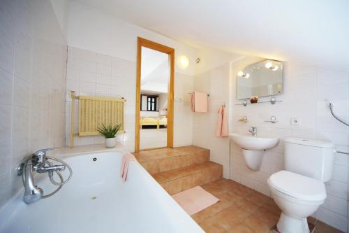 La salle de bains est pourvue d'une baignoire, de toilettes et d'un lavabo. dans l'établissement Restaurace a penzion Jilm, à Jilemnice