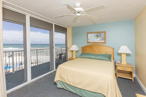 a bedroom with a bed and a balcony with the ocean at Sea Club IV Resort in Daytona Beach Shores