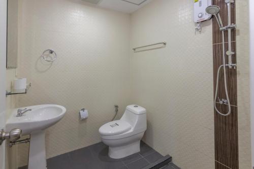 a bathroom with a toilet and a sink at Kontiki Guesthouse in Jomtien Beach
